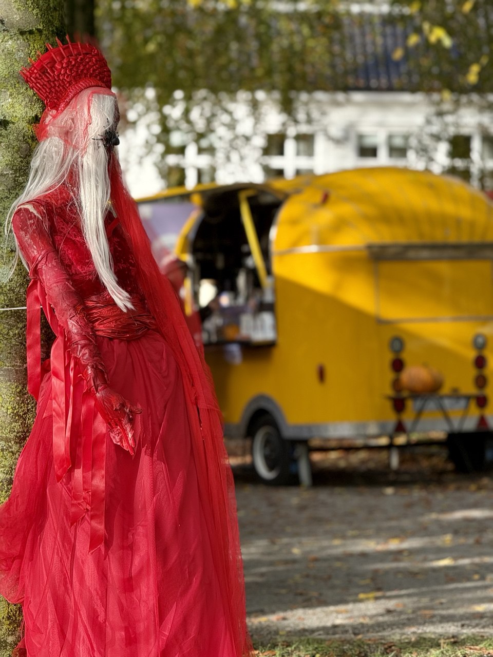 The yellow coffee food truck by Espresso Catering at the autumn Halloween fair, serving premium coffee for adults, hot chocolate, and themed cookies for kids. A festive atmosphere with seasonal treats and warm drinks.